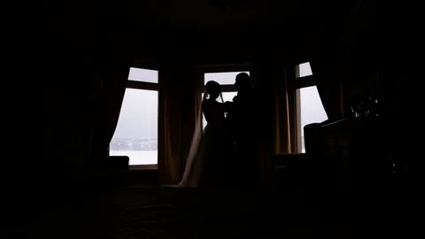 Silhouette of a bride and groom on the background of a window Stock Footage 75385846