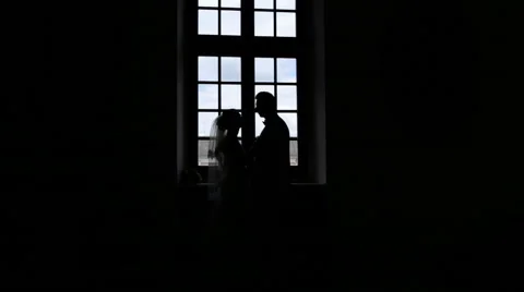 Silhouette of bride and groom in the interior against the window in wedding day. Stock Footage 63570245