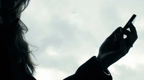 Silhouette. Browsing information on smartphone Stock Footage 33355499