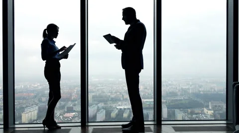 Silhouette of businesspeople comparing data on tablet computer and documents Stock Footage 61295928