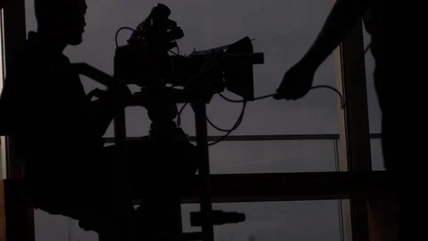 Silhouette of a camera crew working together on set before filming. Stock Footage 123664363