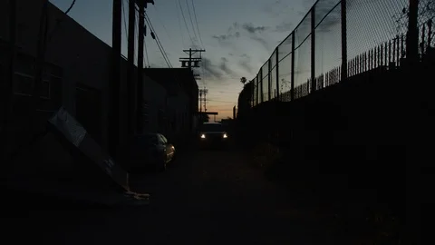 Silhouette of a car coming down an ally at night Stock Footage 106587235