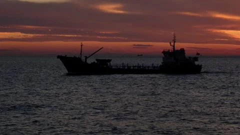 Silhouette of cargo ship going at sunset seascape Stock Footage 266824584