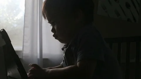 Silhouette of child watching tablet device, video Stock Footage 79720195