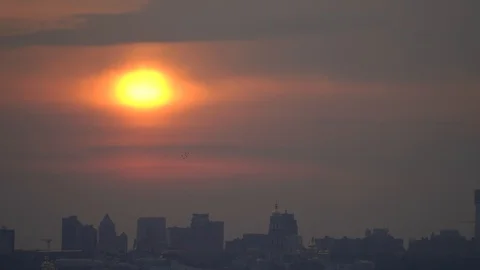 Silhouette of the City Against dramatic Sky During Sunset with sun close up Stock Footage 127216655