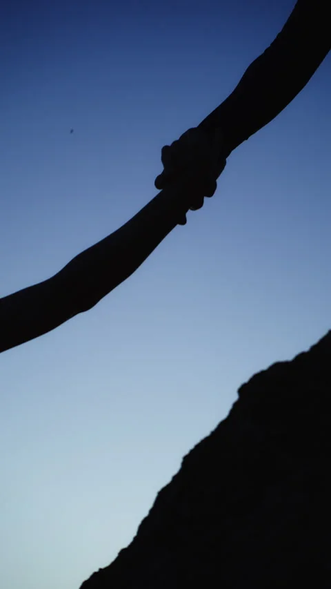 Silhouette of climber receiving help from another person reaching top of mo.. Stock Footage 339911745