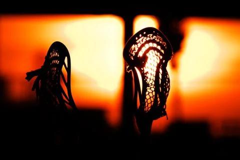 Silhouette close up of  Sunset Lacrosse Sticks, under an orange sunlight Stock Photos