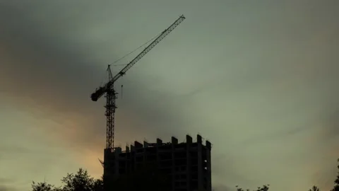 Silhouette of a construction crane at a construction site with an unfinished Stock Footage 201098976