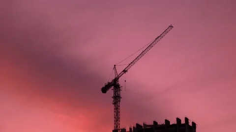 Silhouette of a construction crane at a construction site with an unfinished Stock Footage 201099058