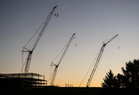 Silhouette of construction cranes Stock Photos