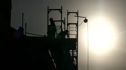 Silhouette construction workers building house using crane and scaffolding Stock Footage 67896649