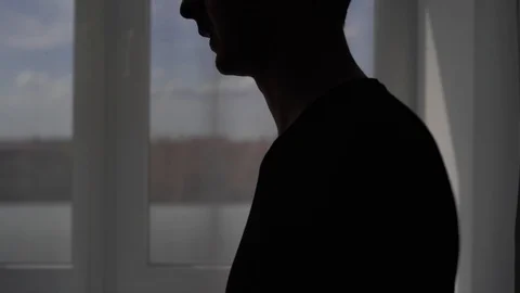 Silhouette of a coughing man on a window background. The patient is treated at Vídeos de archivo 127030696