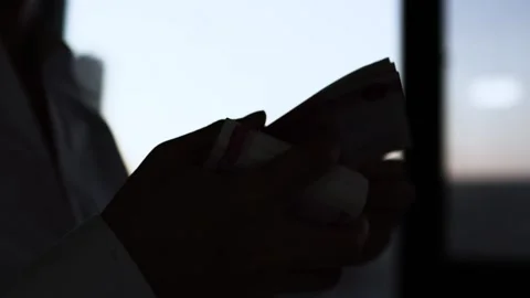 Silhouette of counting money at the window Stock Footage 168114144