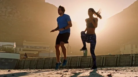 Silhouette of couple exercising at sunset Stock Footage 76521397