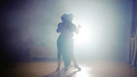 Silhouette of a couple in the fog of dancing tango Stock Footage