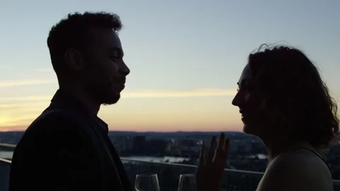 Silhouette Couple Having Drinks On A Skycrapper Terrace At Sunset In The City In Stock Footage 82657147