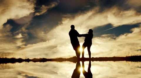 Silhouette of couple holding hands and spinning around. romantic love scene Vídeo Stock 44570853