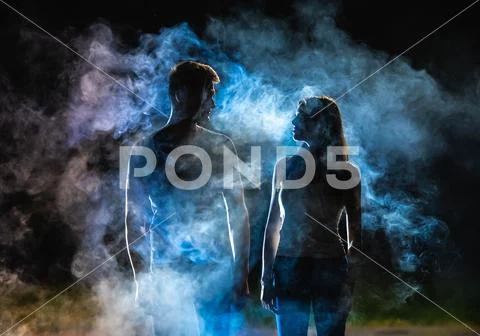 The silhouette of couple in the smoke Stock Photos