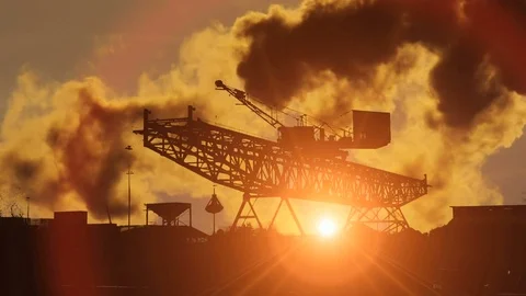 Silhouette of crane moving sand at sunset scenery. industrial smoke polution Video stock 72866933