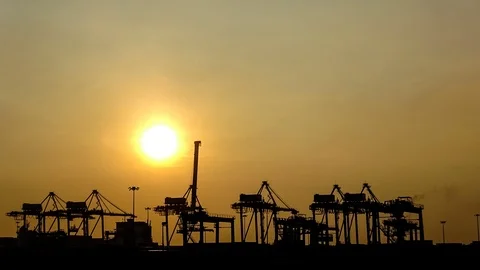 Silhouette of Cranes Loading And Unloading Container Onto Ship During Sunset Video stock 95878550