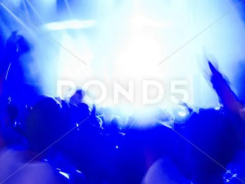 Silhouette Of Crowd Facing Illuminated Stage