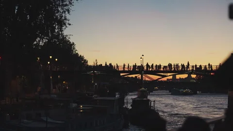 Silhouette of crowd walking on bridge over Seine River at sunset in Paris, 4K Vídeos de archivo 344976045