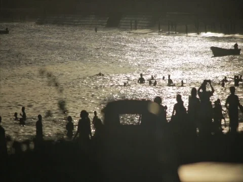Silhouette crowds walk down the beach at sunset. Stock Footage 85012736