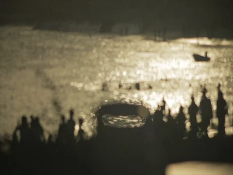 Silhouette crowds walk down the beach at sunset. Stock Footage 85012741