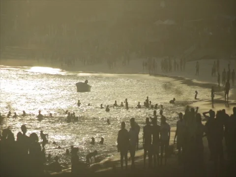 Silhouette crowds walk down the beach at sunset, rack focus. Stock Footage 85012762