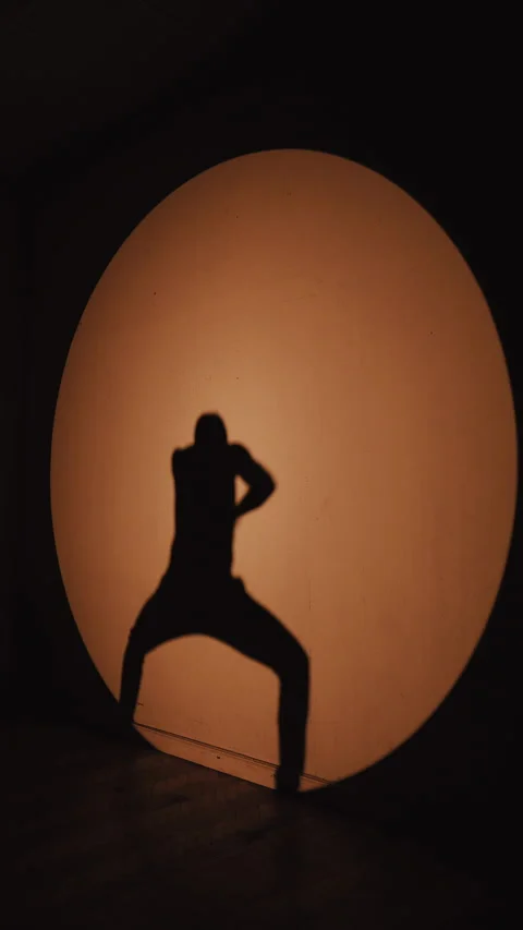 Silhouette of a Dancer Against Dramatic Stage Lighting Stock Footage 303372728