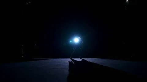 Silhouette of a dancer in move. Performer dancing on stage against spotlights Video stock 149922969