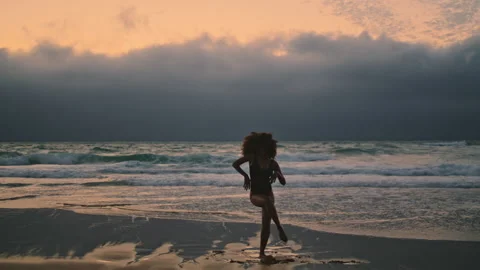 Silhouette dancer performing contemporary style at dramatic cloudy sky on beach. Stock Footage 232811313