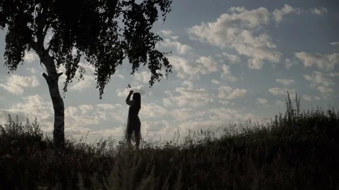 Silhouette of dancing model in grass 库存影片 78883028