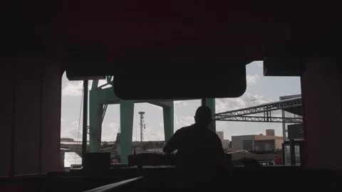 The silhouette of a diligent worker is prominently featured in a bustling port Stock Footage 302084729