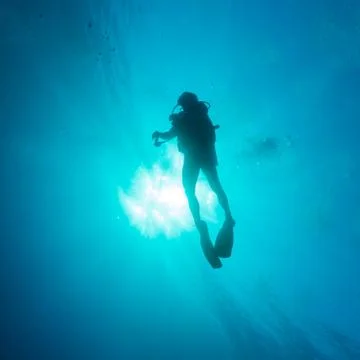 Silhouette of diver with sun disk Stock Photos