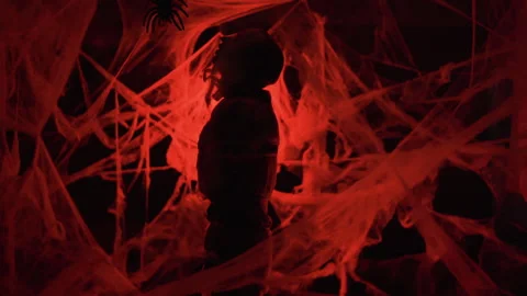 Silhouette Dramatic zombie man trapped in spiderwebs with big spider on red Stock Footage 318902120