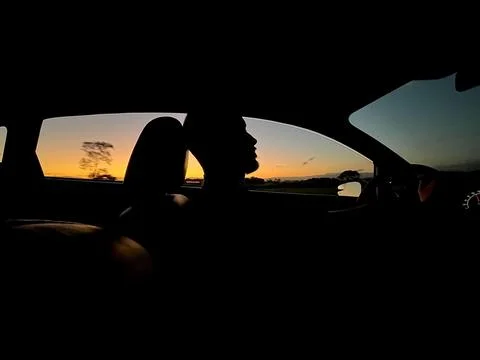 Silhouette of driver at sunset Stock Photos