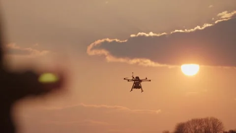 Silhouette of a drone operators hand with a remote control, controlling Video stock 332903255