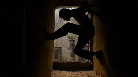 Silhouette of drunk man climbing up a wall in a dance performance Stock Footage 53064019