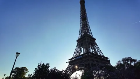 Silhouette of Eiffel Tower with sun shining behind, Paris Vidéo 336551409