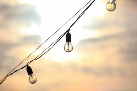 The silhouette of the electric bulb on the background of the setting sun Stock Photos