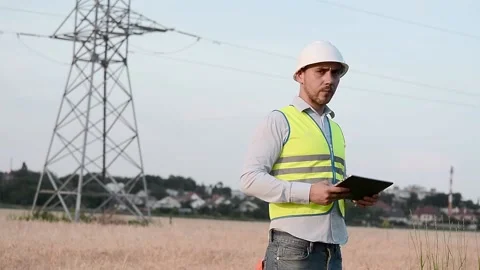 Silhouette of an electrical engineer in hard hat at sunset with tablet. business Vidéo 202652331