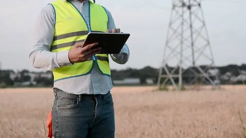Silhouette of an electrical engineer in hard hat at sunset with tablet. business 스톡 동영상 202652459