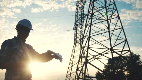 Silhouette of an electrician engineer working next to an electrical support Stock Footage 145467816