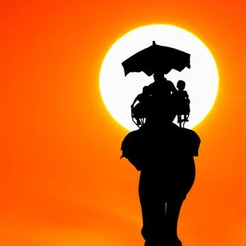 Silhouette elephant with tourist at sunset Stock Photos