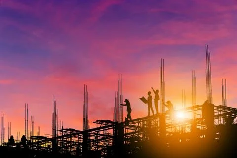Silhouette of Engineer and worker on building site, sunset construction site Photos
