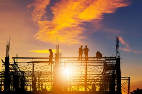 Silhouette of Engineer and worker on building construction site at sunset Fotos de archivo