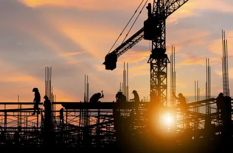 Silhouette of Engineer and worker checking project at building site background Photos