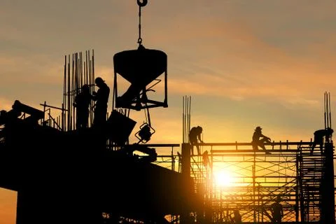 Silhouette of Engineer and worker checking project at building site background Stockfoto's