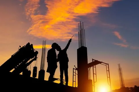 Silhouette of Engineer and worker checking project at building site 写真素材